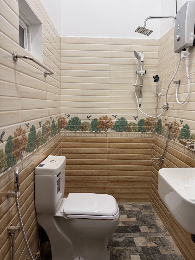 Clean tiled bathroom with shower, sink, and toilet