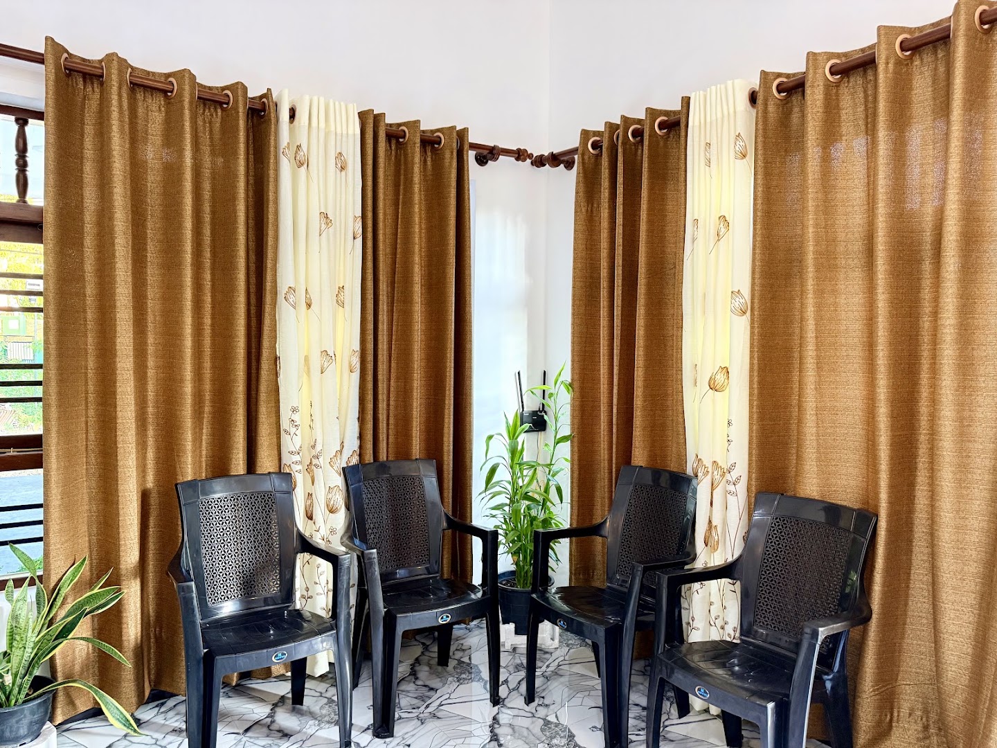 Shared seating area with brown curtains and potted plants